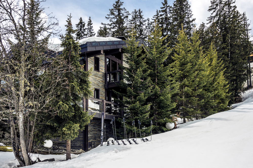 Chalet Tahion on the edge of ski slopes with trees in front