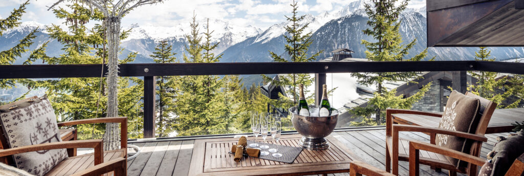 Terrace facing the mountains with chairs and table with champagne bottle and glasses on
